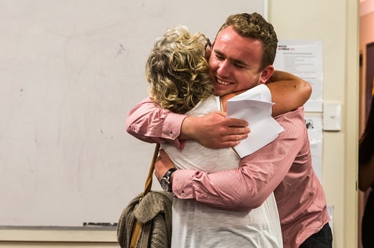young person hugging mother at triple care farm graduation
